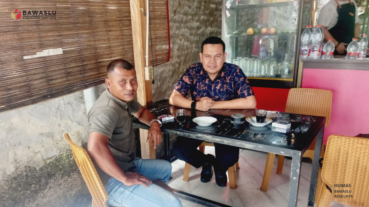 Anggota Bawaslu Aceh Jaya, Hidayatullah, sedang melaksanakan Konsolidasi Demokrasi bersama Anggota PWI Aceh Jaya, Aswar Dani, di sebuah warung kopi di Calang.