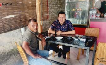 Anggota Bawaslu Aceh Jaya, Hidayatullah, sedang melaksanakan Konsolidasi Demokrasi bersama Anggota PWI Aceh Jaya, Aswar Dani, di sebuah warung kopi di Calang.
